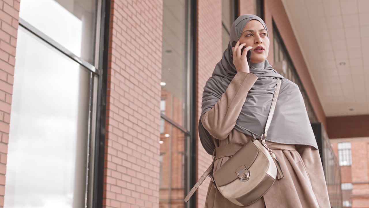 Arabic Woman Talking on Phone during City Walk
