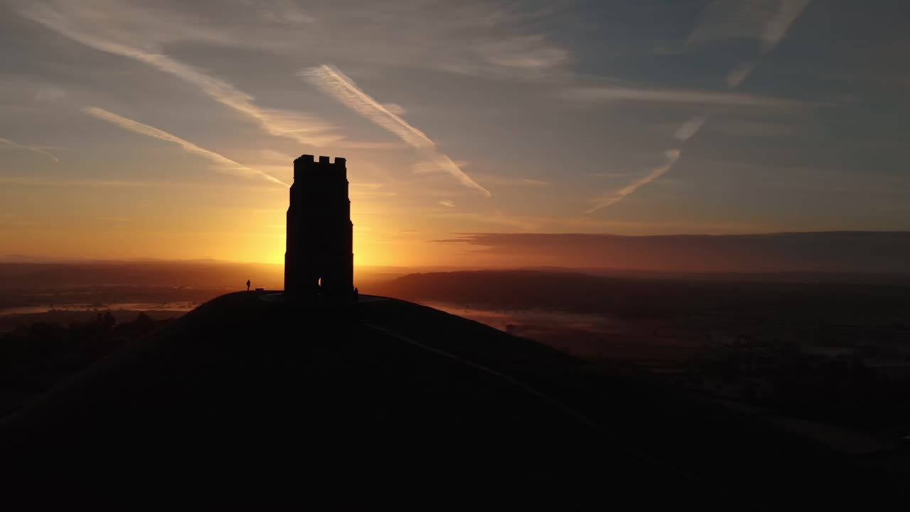 Orbiting the golden sunrise over Glastonbury Tor and the misty fields below
