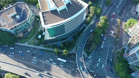 top-down drone shot of an office building at the intersection of coronation drive and the go between bridge, showcasing traffic below on a sunny afternoon