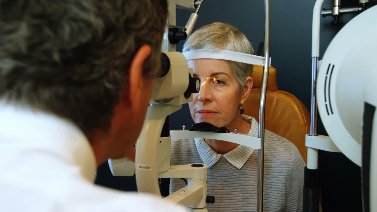 Optometrist examining patient eyes with slit lamp 4k