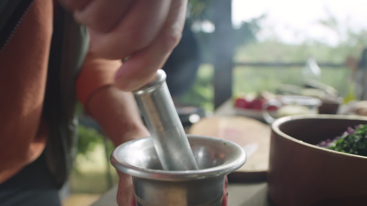 Man Using Mortar and Pestle on Outdoor Terrace