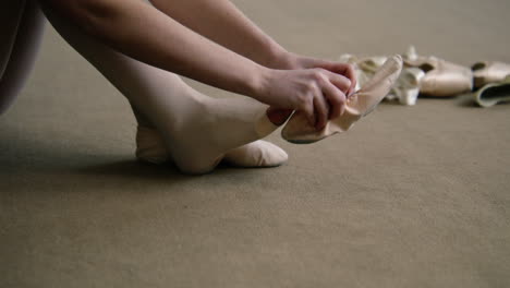 una bailarina que se pone zapatos de punta