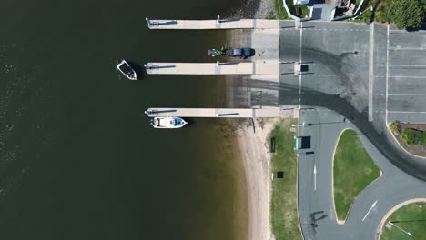 recreational vessel slowly moving away from a public boat ramp and pontoon