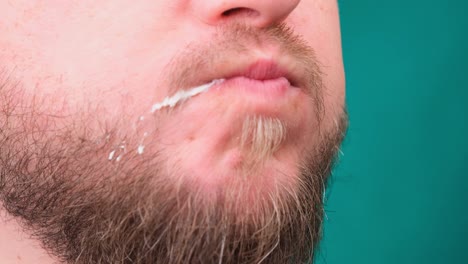 close up of a man biting a burger on a chroma key. the concept of unhealthy and unhealthy diets, high cholesterol