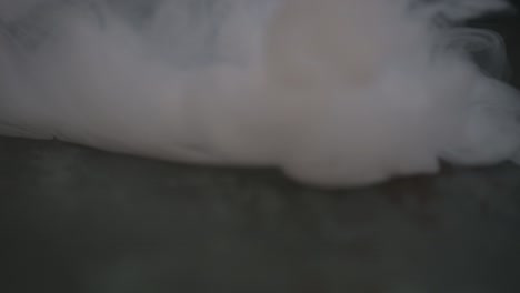 humo cayendo de arriba a abajo en una superficie oscura