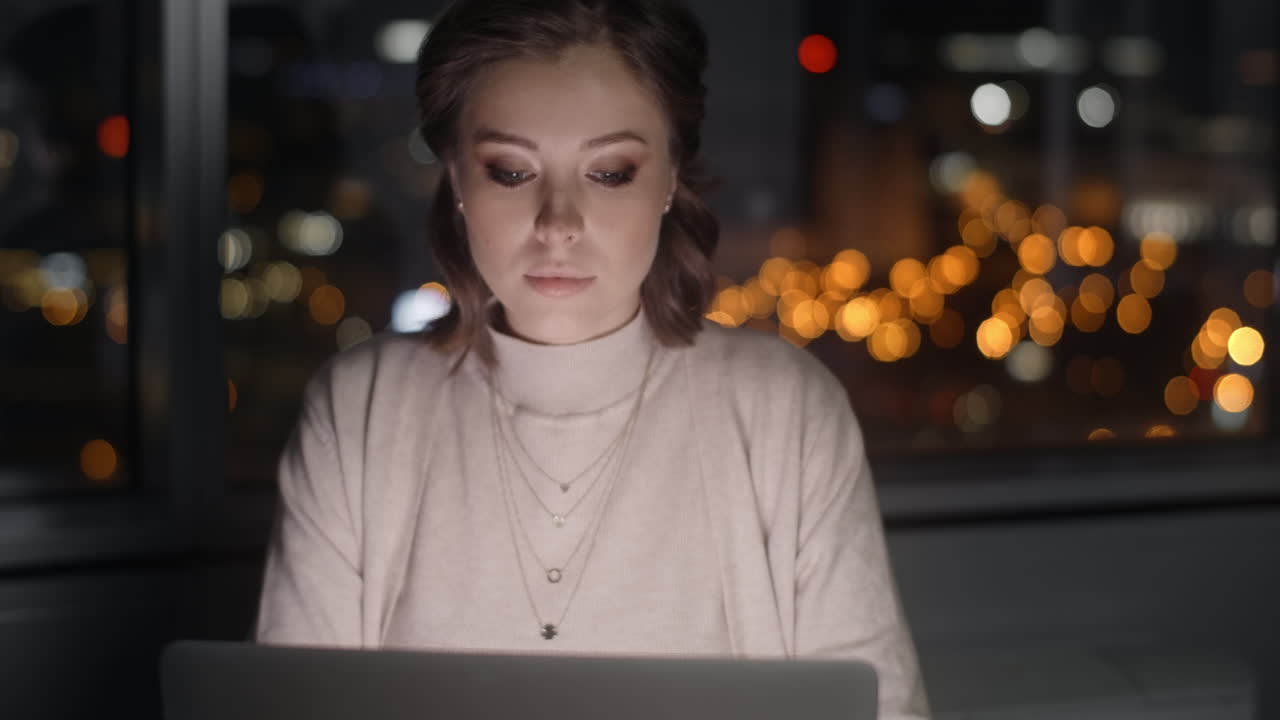 mujer trabajando en la computadora portátil por la noche