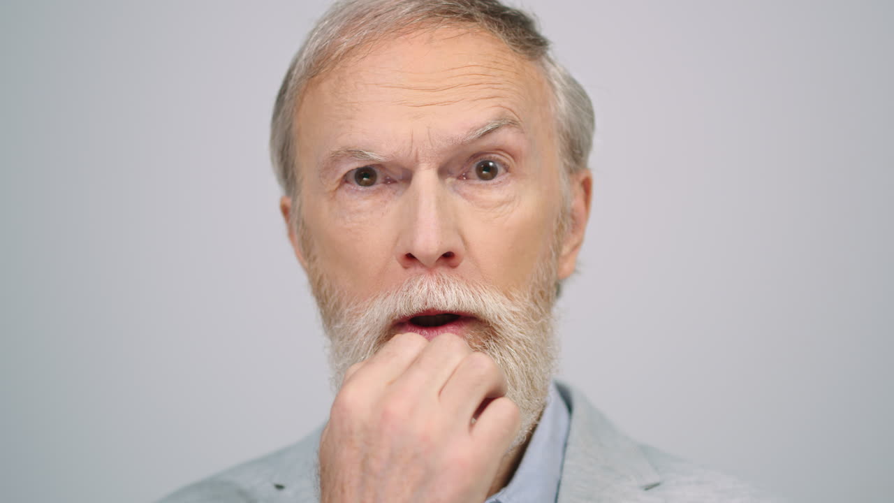 Uomo allegro che punta il dito verso l'alto in studio. Signore entusiasta che pensa in interni.