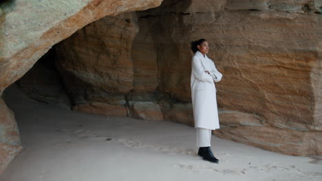 sad woman contemplating problems hiding at seashore rock. pensive model resting