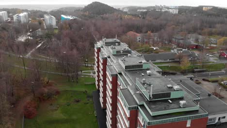 Aerial-dolly-shot-apartments-red-buildings-with-seagulls-flying-around,-Morning-lights