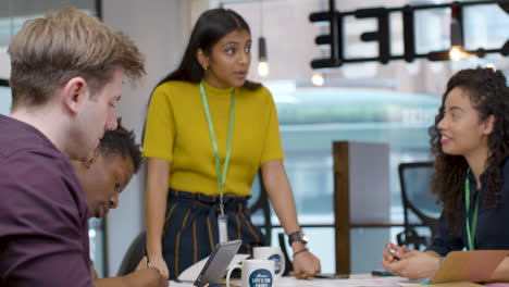 Tracking-Out-From-Businesswoman-Presenting-To-Colleagues-In-Meeting