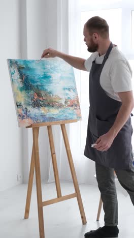 vertical video artist uses talent and tie dye to create a masterpiece on canvas in workshop