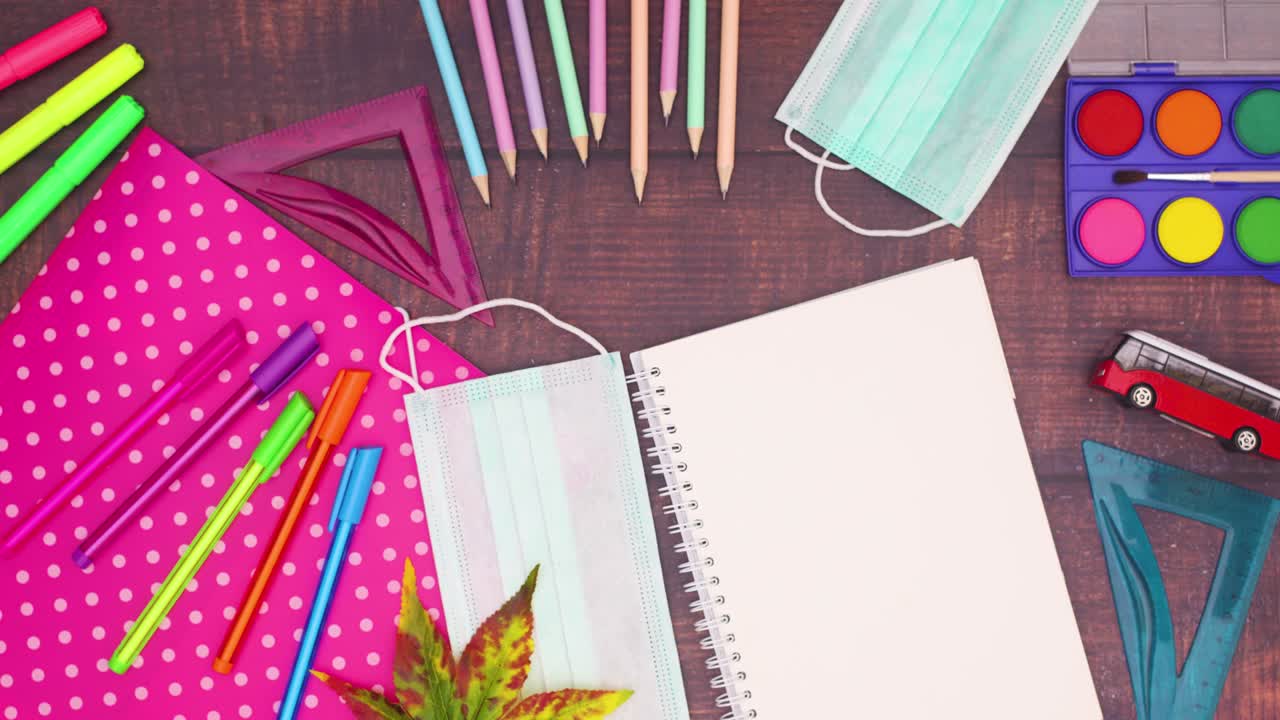 школьные принадлежности появляются на деревянном столе.