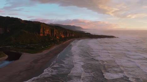 Vuelo-Panorámico-De-Drones-Aéreos-Durante-Una-Hermosa-Puesta-De-Sol-Sobre-Rocas-De-Panqueques-En-Punakaiki-Con-Acantilados-Escarpados-Y-Vistas-Al-Océano-En-La-Costa-Oeste-De-La-Isla-Sur,-Nueva-Zelanda-Aotearoa