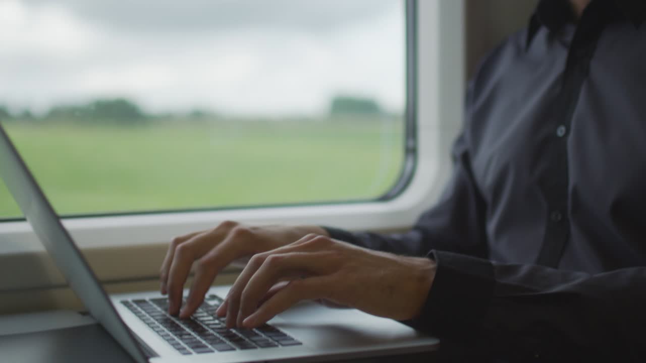 hombre trabajando en una computadora portátil durante un viaje en tren