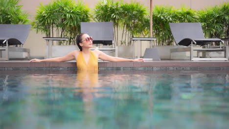 fashionable woman in swimming pool shot above water surface soft focus