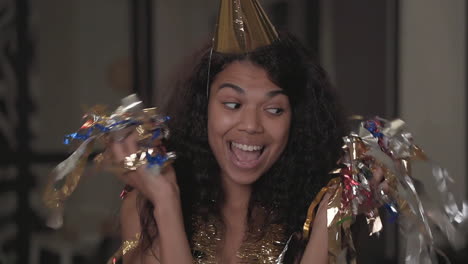 portrait of a beautiful black woman making funny faces, dancing, throwing confetti at new year's eve party