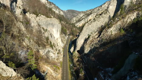 cars driving over the road in the jura gorges at moutier in switserland no a cold sunny autumn day with snow in the shadows