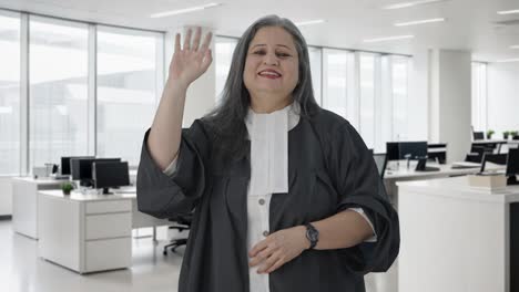 Happy-Indian-senior-female-lawyer-saying-Hello-and-waving