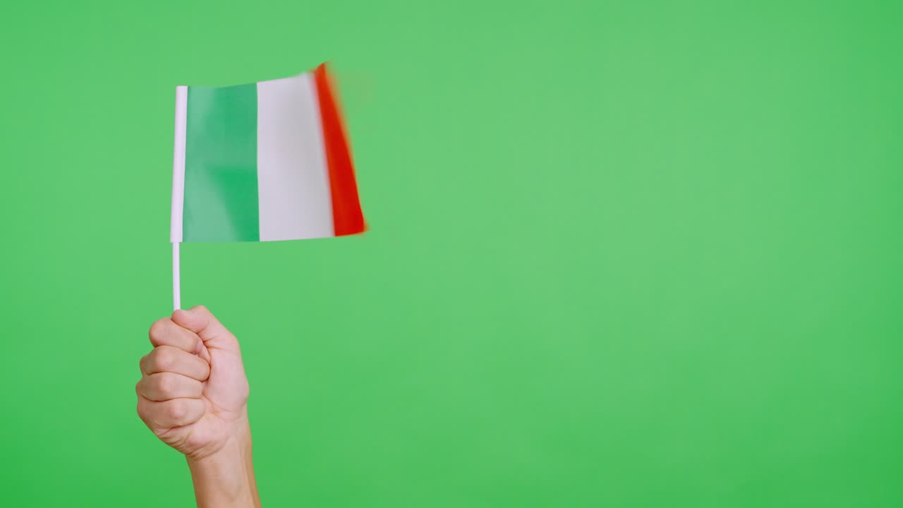 Il vento che agita un gagliardetto italiano tenuto da una persona