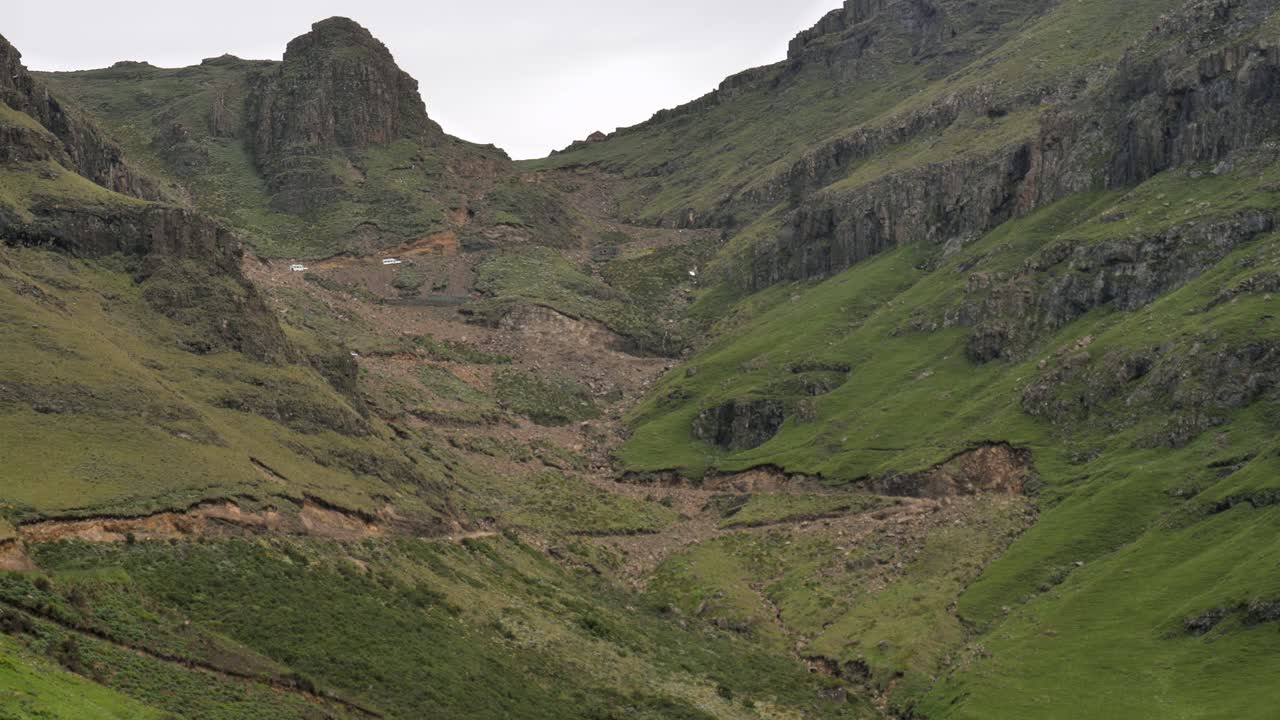 Time-lapse di camion bianchi che salgono sui tornanti sterrati e accidentati del Sani Pass