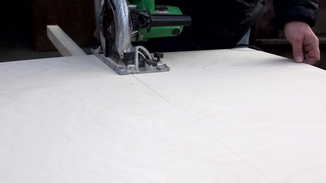 резать дерево с помощью электрической ручной пилы. деревообработка.