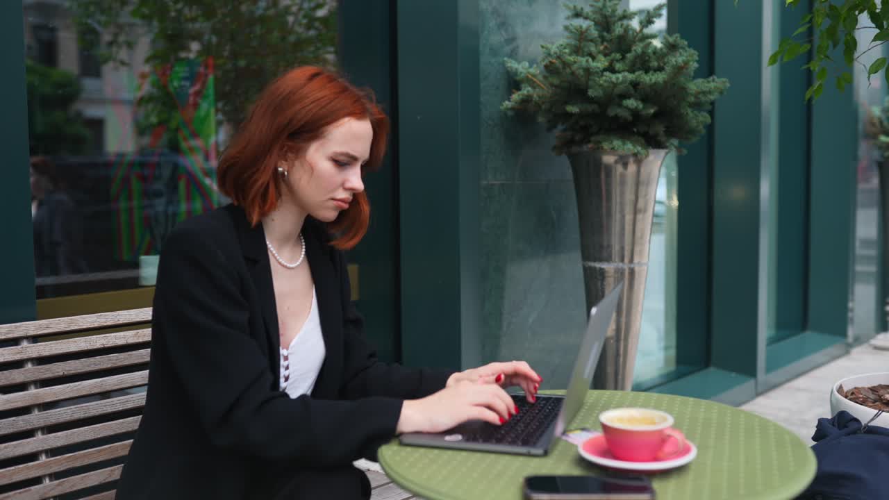 Woman working on laptop in a cafe