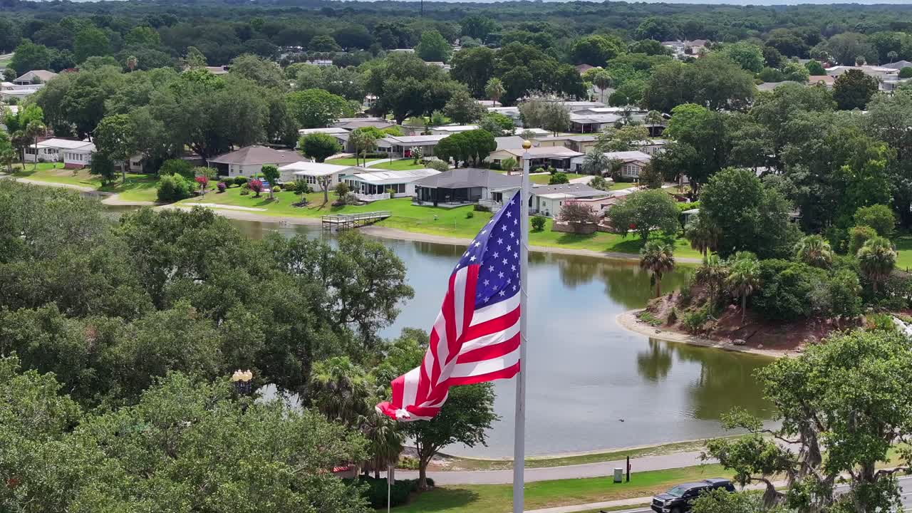 bandera estadounidense ondeando frente al vecindario de florida en las aldeas, fl
