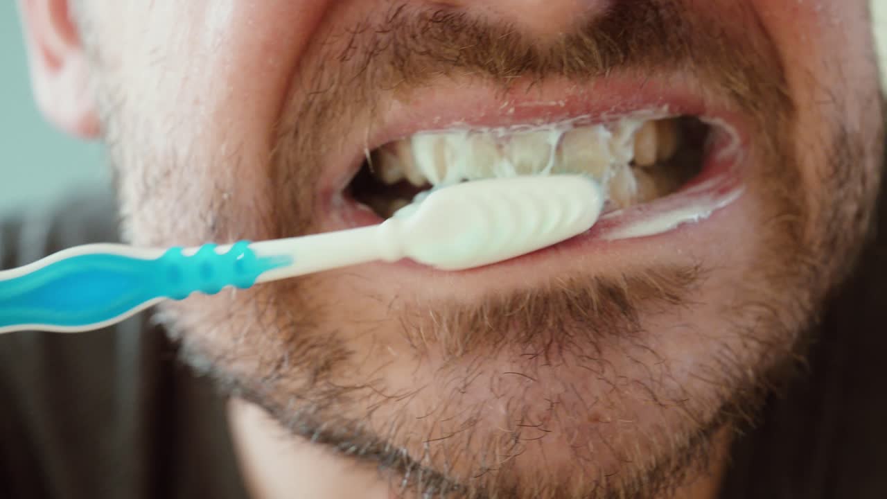 close-up of a man brushing his teeth using a circular motion technique. Concept of proper oral hygiene, dental care routine, and healthy toothbrushing method