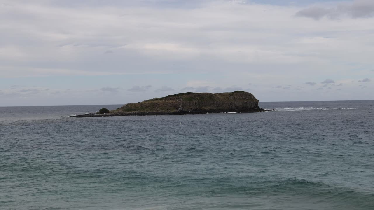 Onde che si infrangono e si ritirano intorno a sereni isolotti oceanici