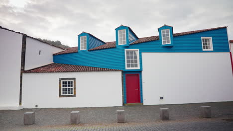 wide shot of the exterior of modern wooden house with red painted door