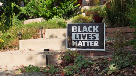 black lives matter yard sign next to front steps of house