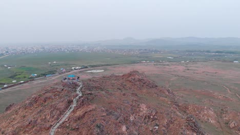 Aerial-Flyover-Prayer-Flags-on-Red-Rocky-Mountain-Point-in-Mongolia