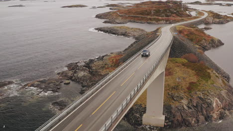 car crossing magnificent storseisundet bridge on atlantic ocean road, norway