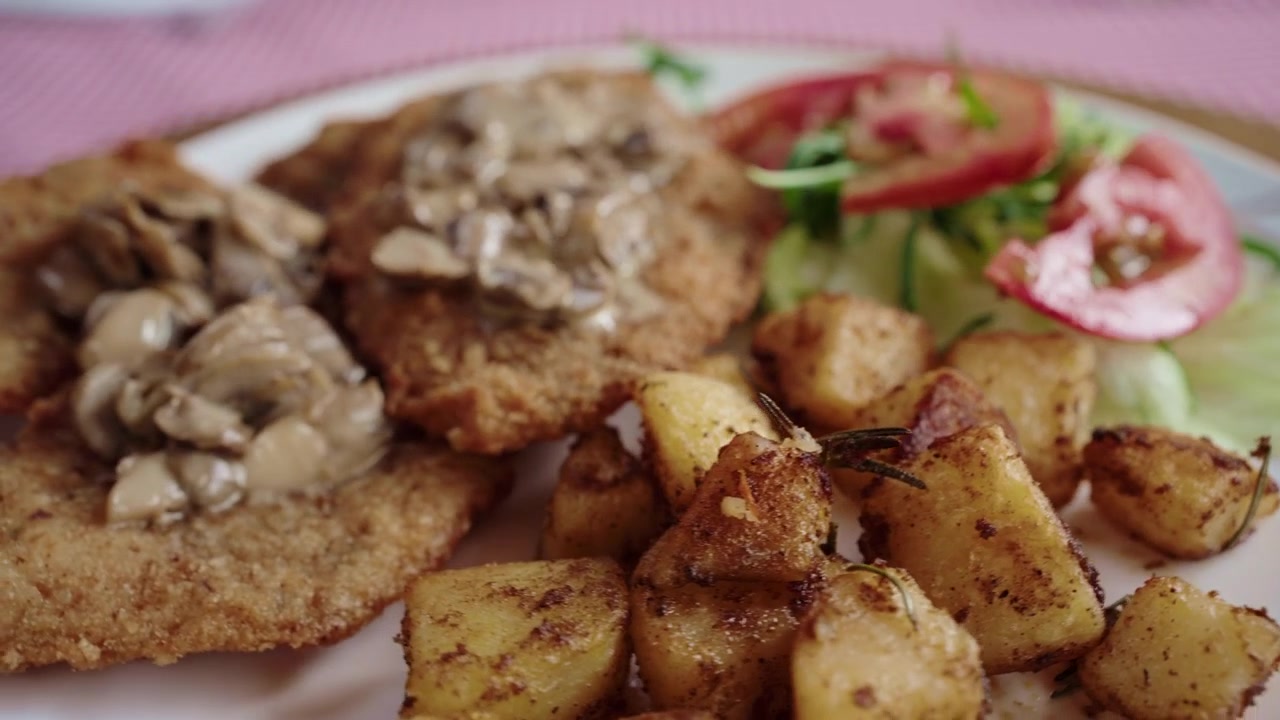 Piatto di pollo impanato, fritto, con crema di funghi, patate arrosto, insalata