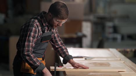 young carpenter clamp the board with carpenter's clamps