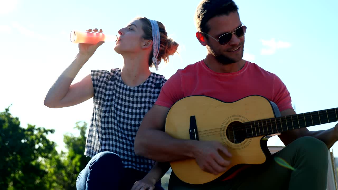 hombre tocando la guitarra para mujer 4k