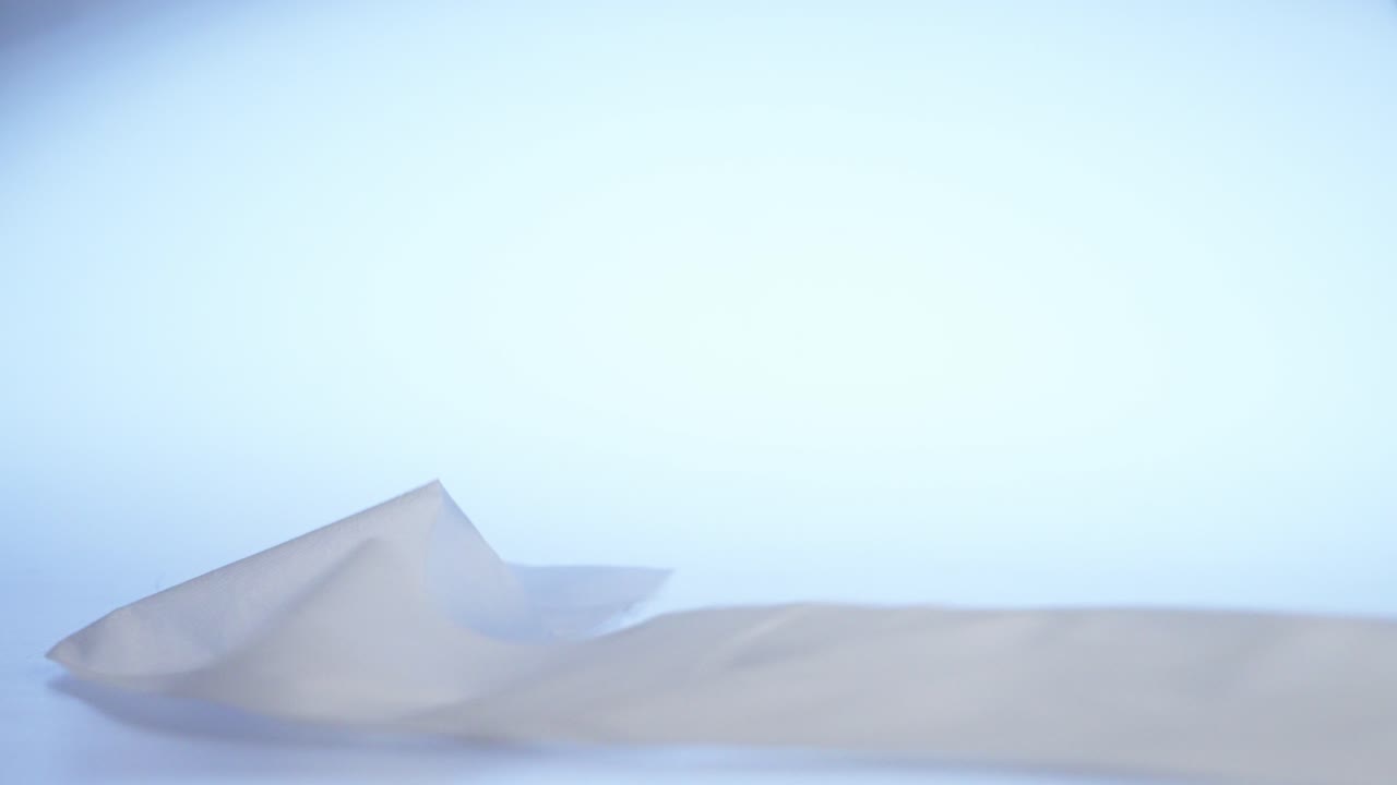 신선하고 부드럽고 매끄럽고 부드러운 화장지 롤, 파란색 백라이트로 장면에서 튀어 나옵니다.