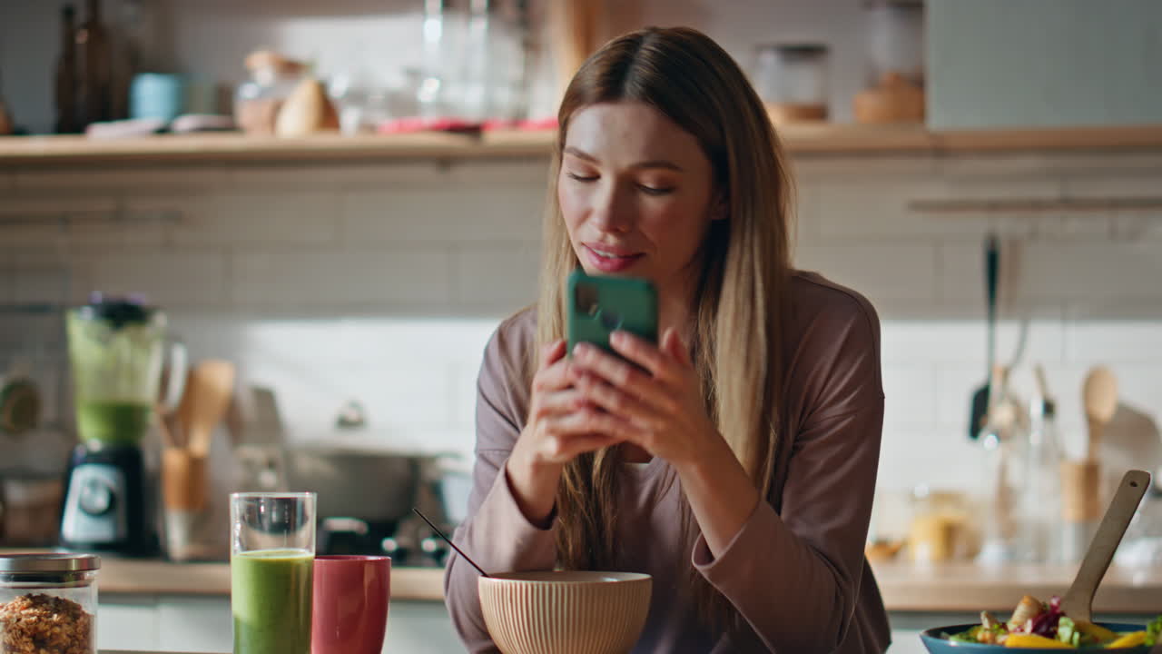 Home lady reading sms at mobile phone having weekend breakfast kitchen close up.