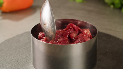 preparing raw beef for a dish