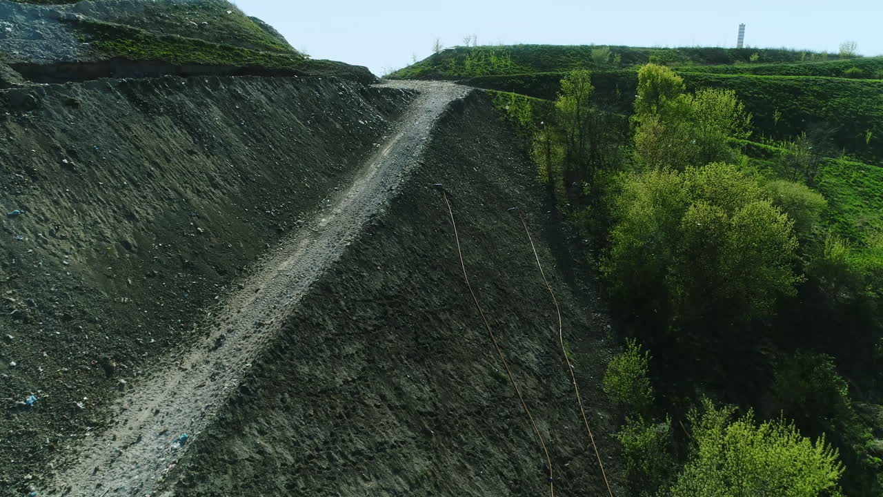 vista desde arriba de la ladera de una colina hecha de basurero
