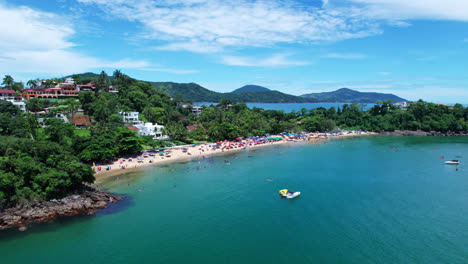 aerial view towards perenque-mirim beach, tropical sandy beach crowded with tourists, ubatuba, brazil