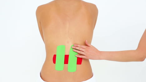 woman having red and green kinesio tape applied to back