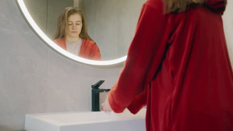 mujer lavando las manos en un baño moderno