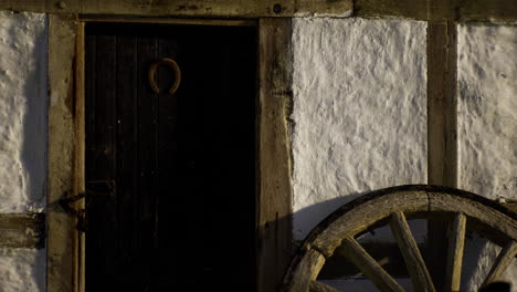 rustic wooden wheel next to an old door reveals village charm at sunset