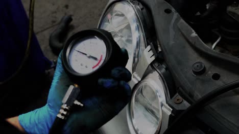 a technician carries-out an oil pressure test on an engine