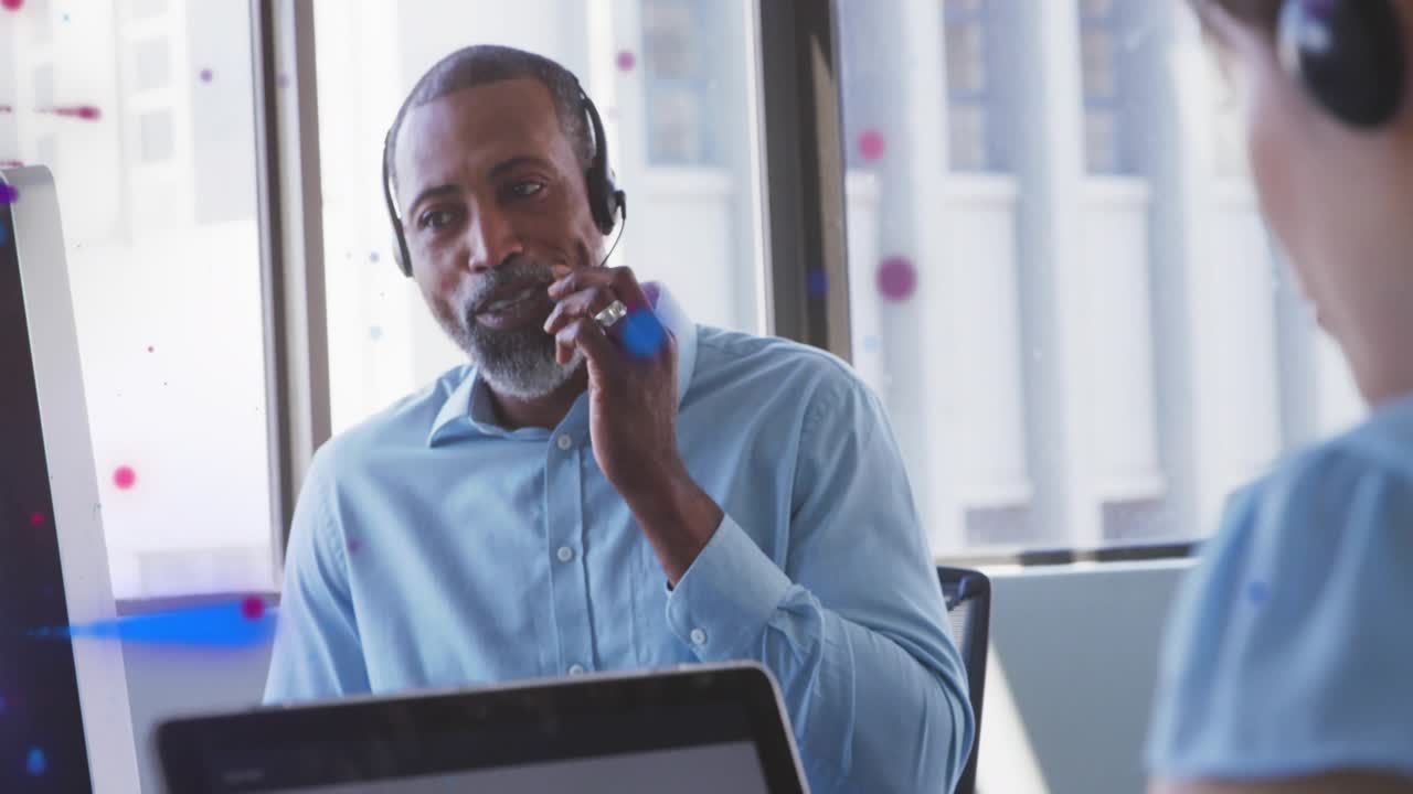 Leaning forward greeting coworker sparking colorful particle overlay around man during office chat