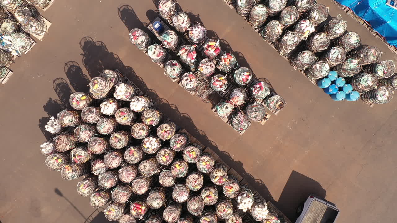 крабовые клетки и клетки для омаров, сложенные в доке у пристани, вид сверху вниз с дрона