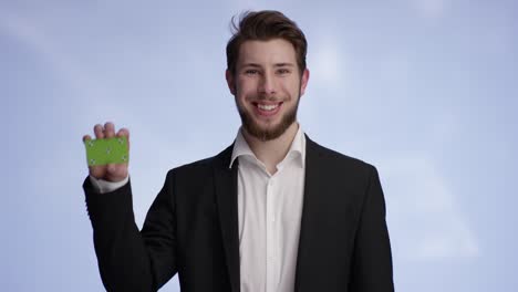 young attractive man smiling and holding your buisness card