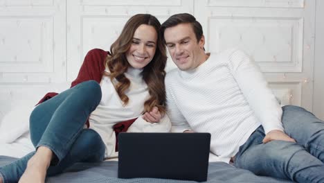 pareja feliz viendo películas en la computadora en casa juntos.
