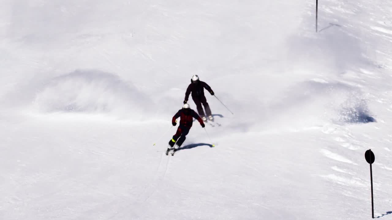 2명의 남자 스키 강사가 짧은 스키 턴을 스키